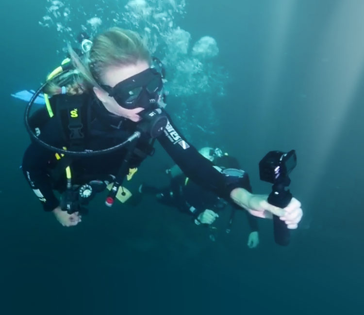Two divers using the KeyMission 170 and accessories to film underwater