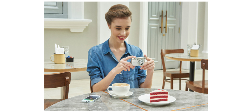 Woman taking a picture of cake with an affordable digital camera.