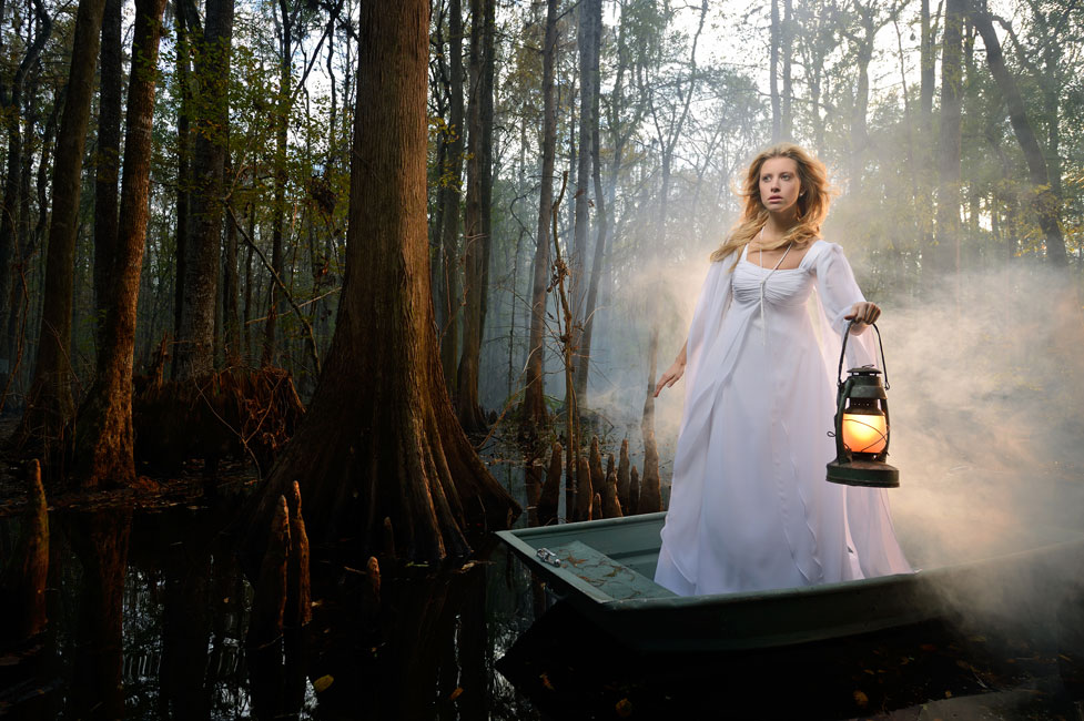 Joe McNally photo of a model on a small boat in a swamp