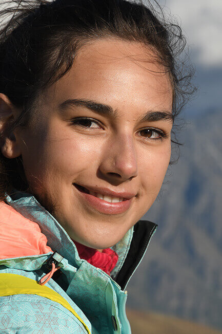 A girl looks into the camera while hiking