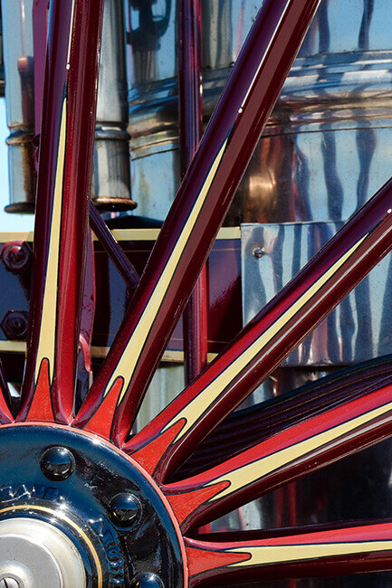 A close up of brightly painted red spokes on a metal wheel