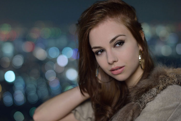A young woman posing with the bokeh effect in the background