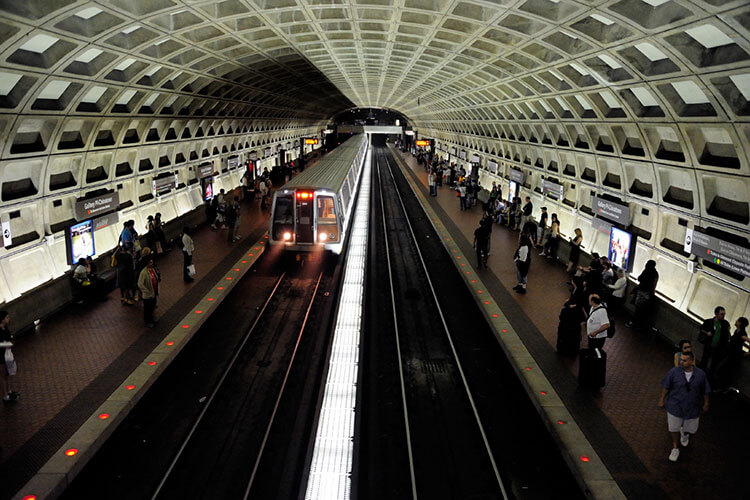 Looking down a subway plaform while passengers board the train