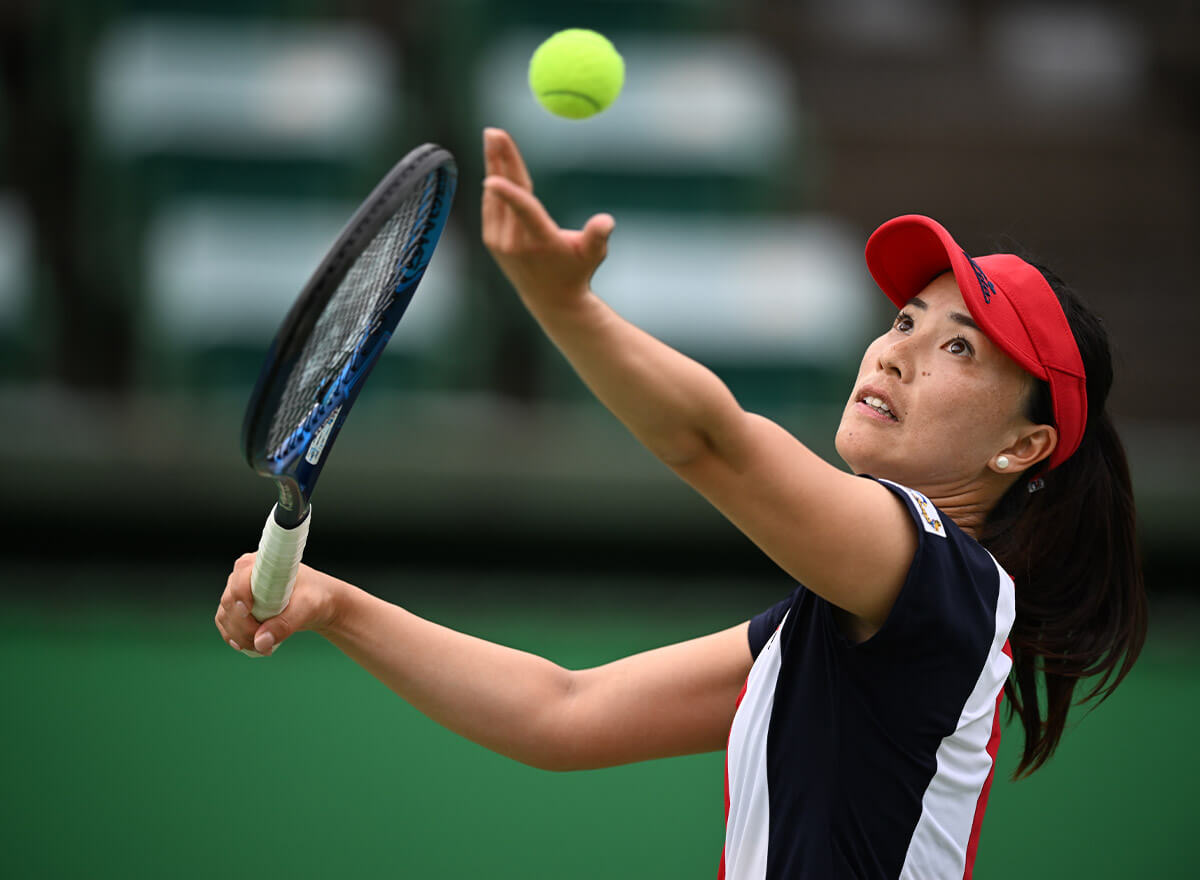 Photo of a female tennis player about to serve the ball