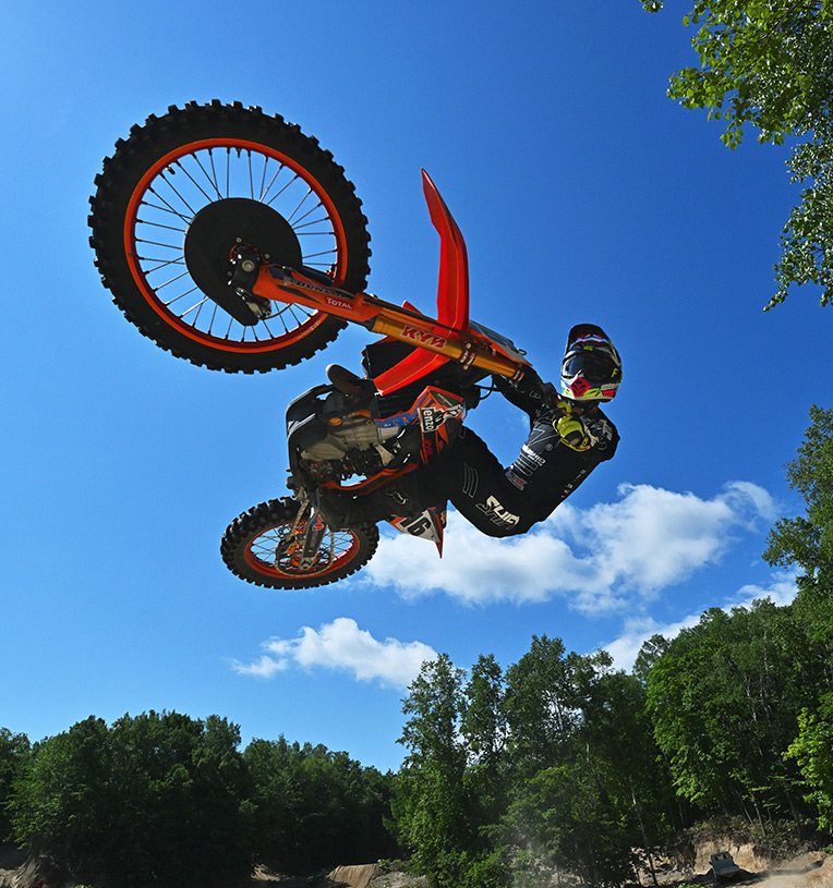 Photo of a motorbike rider in air on a red bike