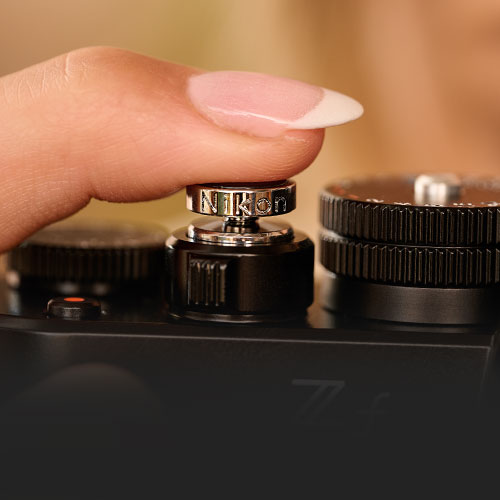 Photo of a woman's finger pressing the soft shutter release button of the Z f camera