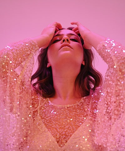 Photo of a female model in a sparkly dress, with a pink hue, taken with the Nikon Z f camera