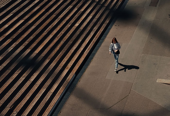 Photo of a person walking on a sidewalk, taken from high above, showing leading line steps, taken with the Z f