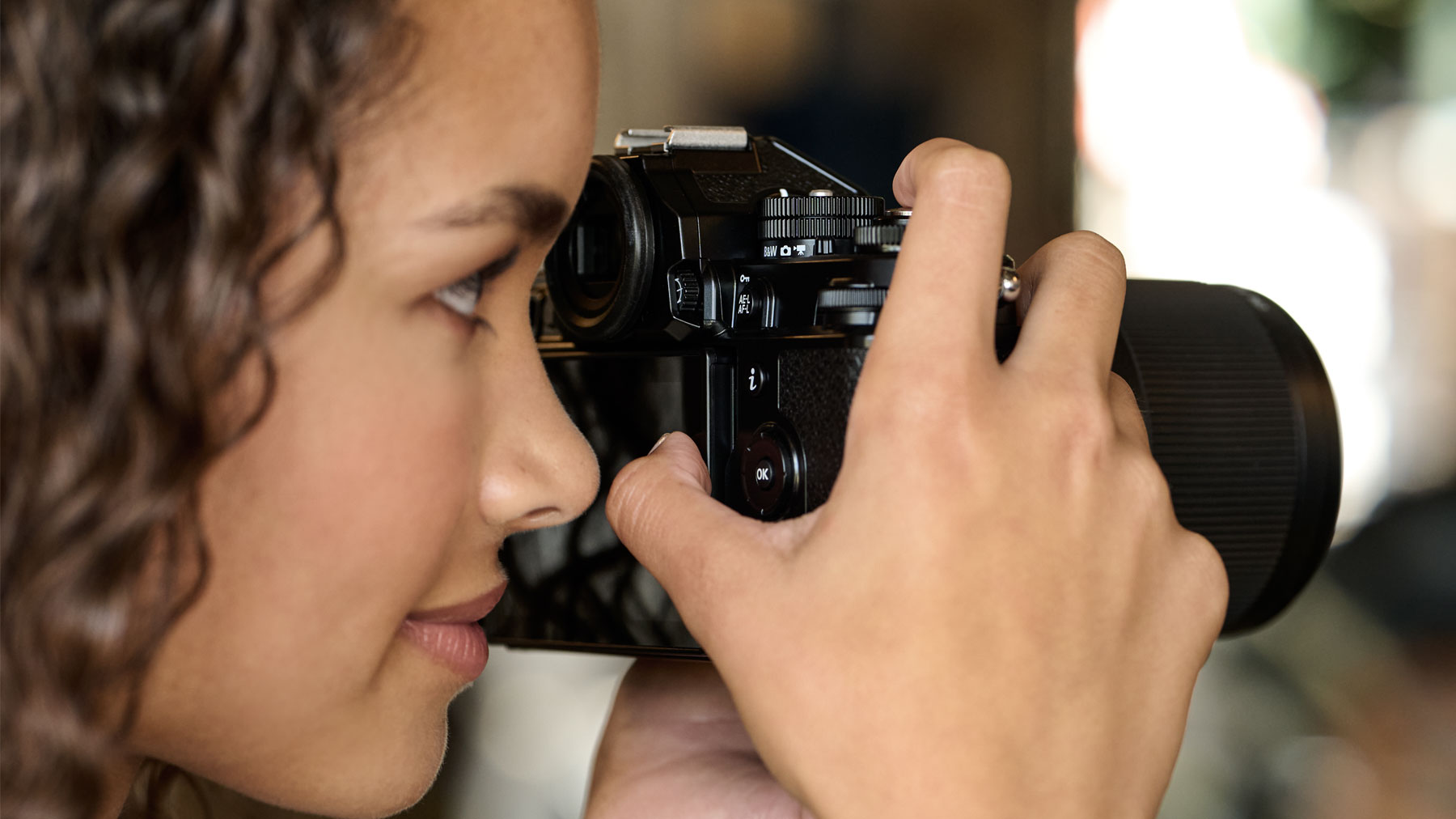 Photo of a woman with the Z f camera to her eye, getting ready to take a photo