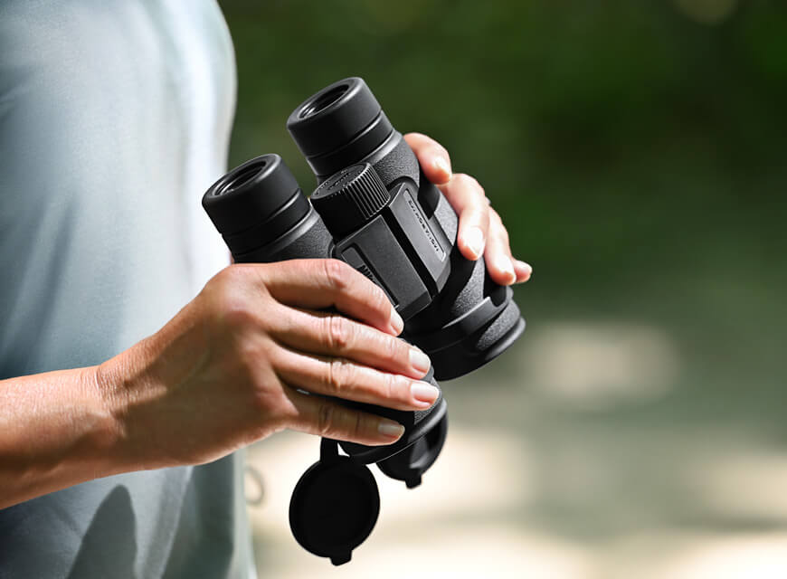 Photo of a person holding a pair of Monarch M5 binoculars