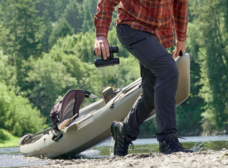 Photo of a person dragging a kayak while holding a pair of Monarch M5 binoculars