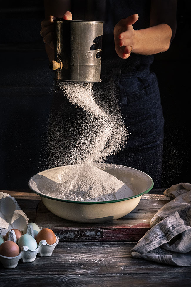 photo of a person sifting flour